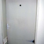 Старата врата с повредена каса и захабена боя.